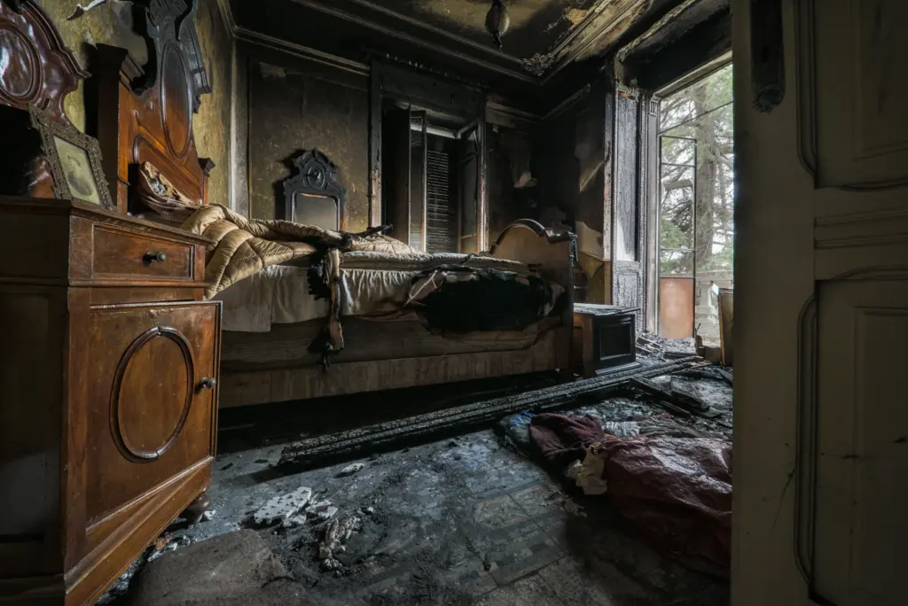Camera di una villa abbandonata dopo un incendio fotografata in stile fine art